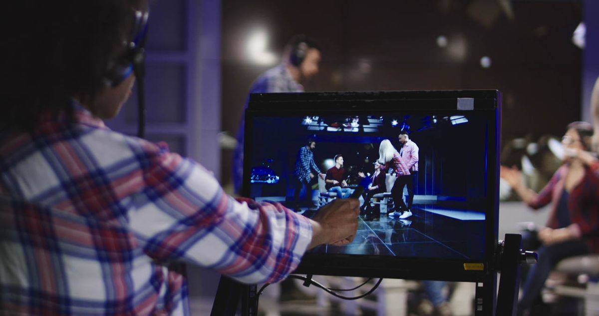 Teen points to video display as videotaping occurs in the studio