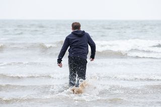 Charlie Dean wades into the sea