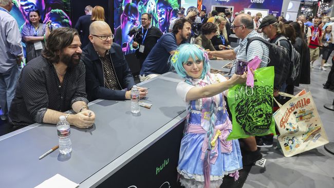 Matt Berry (l.) and Mark Proksch of FX&rsquo;s What We Do in the Shadows take a selfie with a fan during a July 25 signing at San Diego Comic-Con.