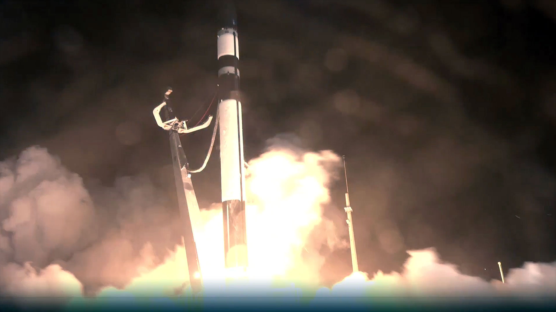 a white and black rocket lifts off into the night sky