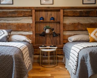 Cabin style twin guest room with original wood features, and cozy textiles for hunker down appeal.