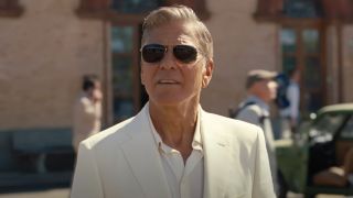 George Clooney as Jay Kelly, watches from behind shades as his daughter drives away on a bus.