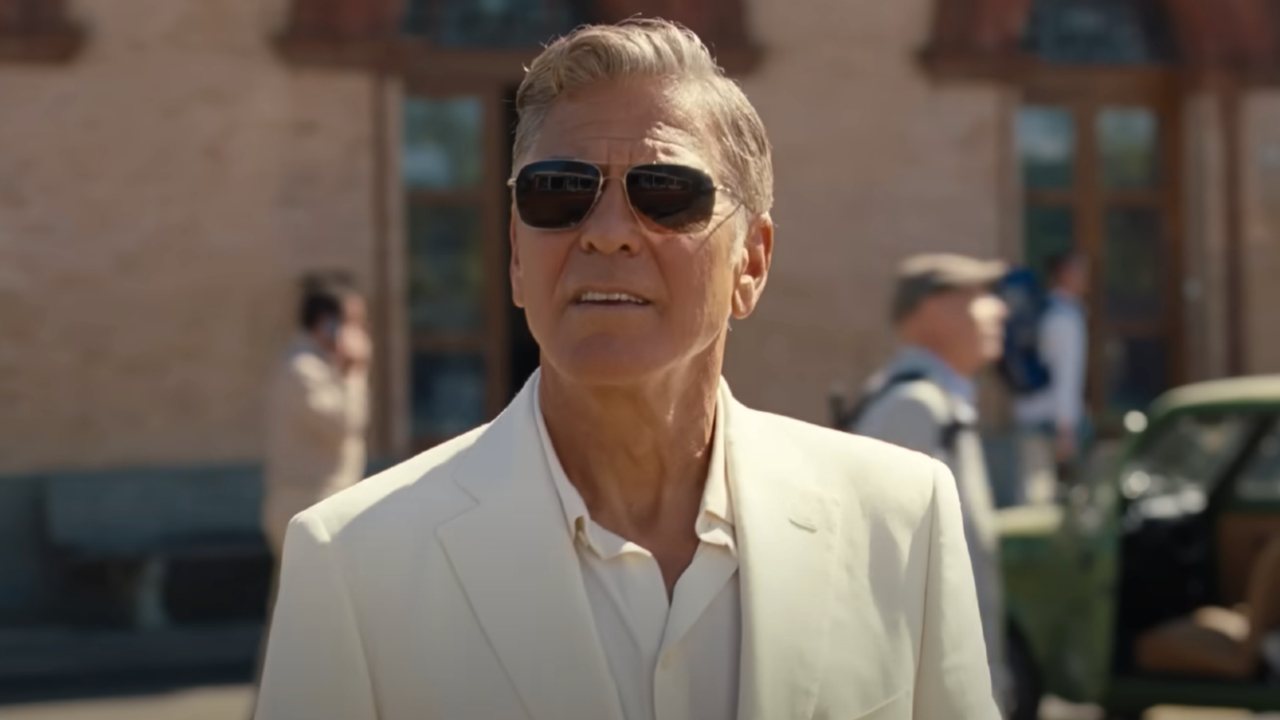 George Clooney as Jay Kelly, watches from behind shades as his daughter drives away on a bus. 