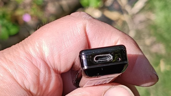 Zanco Tiny T1 phone in hand with USB socket pointed at camera