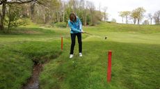 Player touching ground with club in penalty area during practice swing