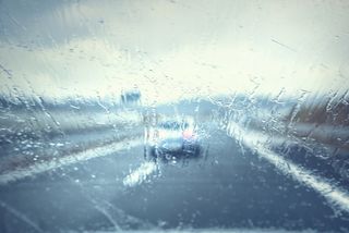 Abstract blurred vehicle dangerous highway driving in heavy rainfall. Stormy conditions on the highway. Blur effect visualizes the speed, poor vision and dynamics at high speed.