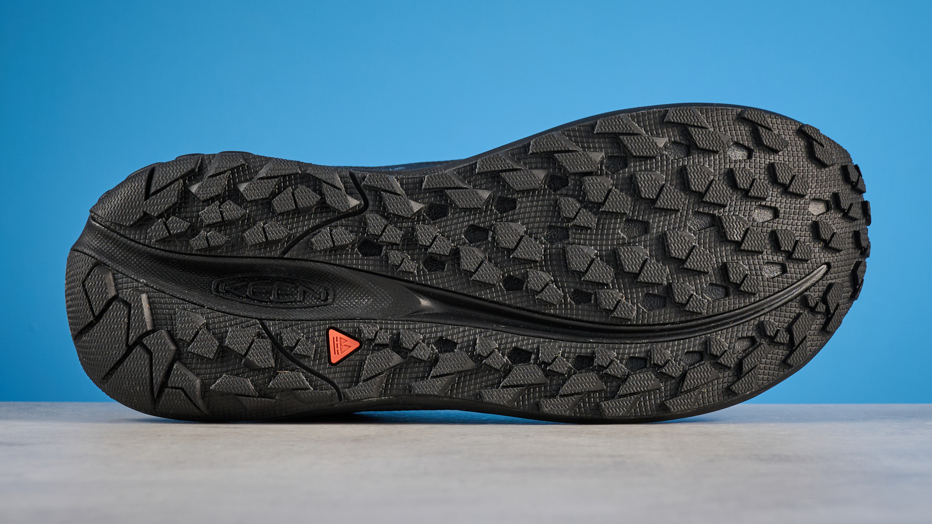 Keen Roam train running shoes in black photographed in front of a blue background