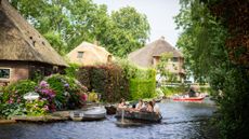 People take a boat tour on the canals surrounding the historic houses in the village of Giethoorn, known as the 'Venice of the Netherlands' 
