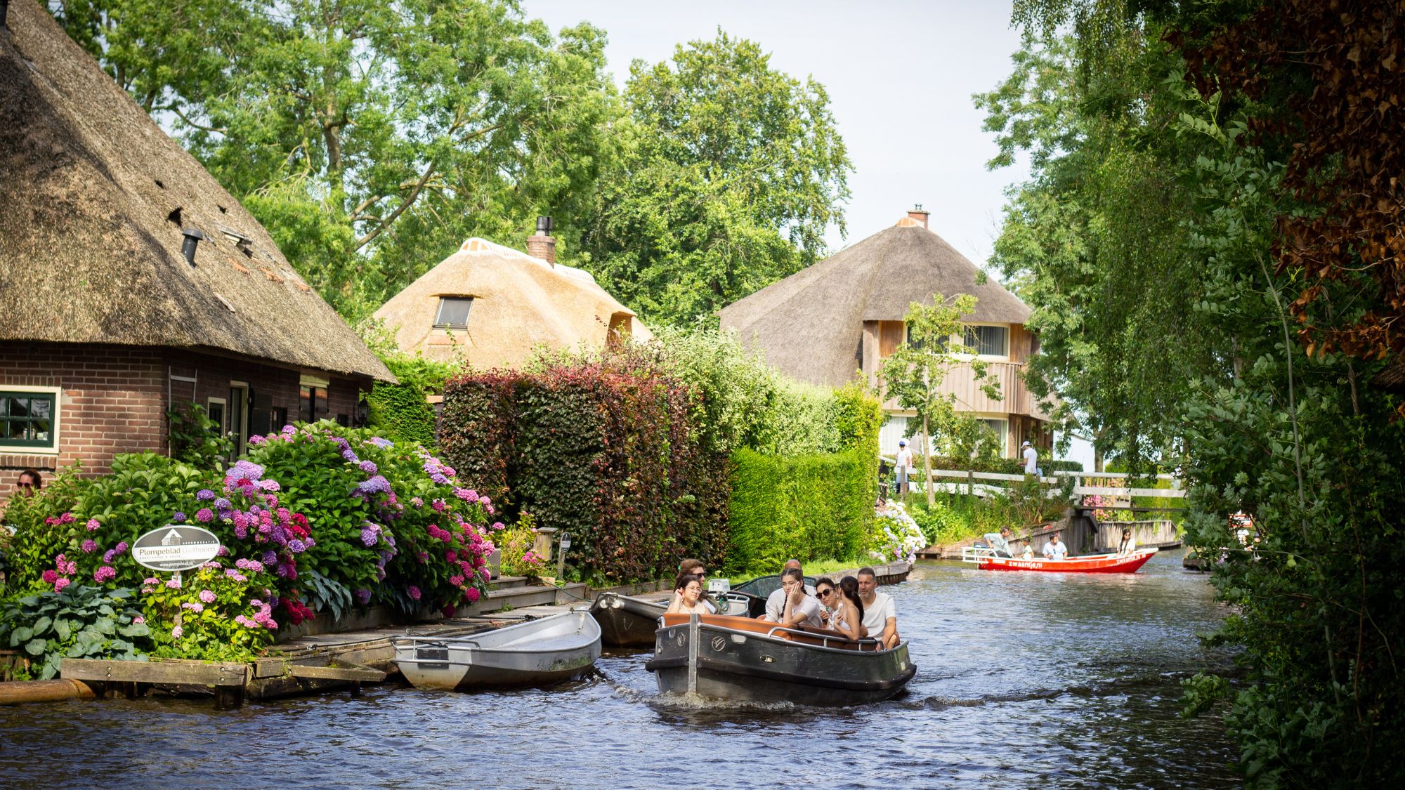 People take a boat tour on the canals surrounding the historic houses in the village of Giethoorn, known as the 'Venice of the Netherlands' 