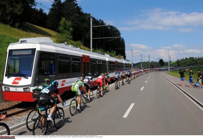 The peloton passes a train