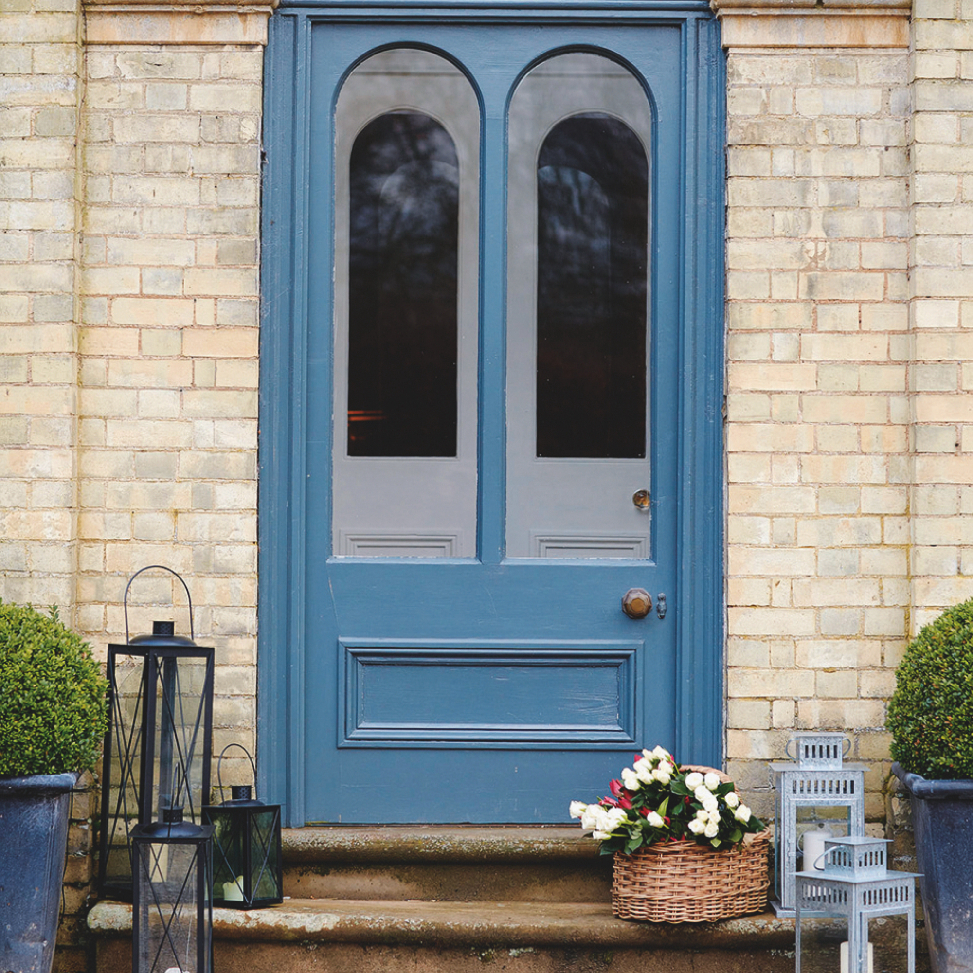 small front porch ideas, blue door with double doors in porch, basket of tulips, lanterns on steps