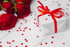 St. Valentines Day. Red roses and gift box on wooden table