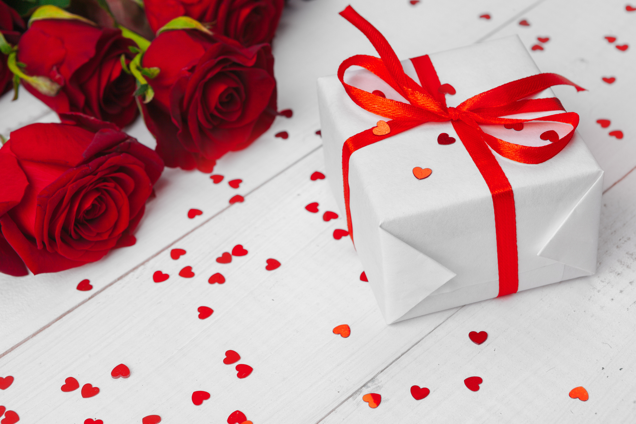 St. Valentines Day. Red roses and gift box on wooden table