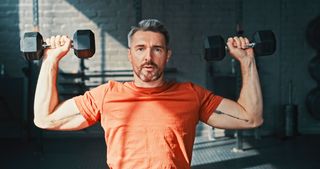 a photo of a man holding a set of dumbbells