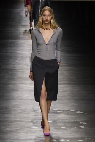 Gucci model wearing a gray top and pencil skirt on the SS24 runway.
