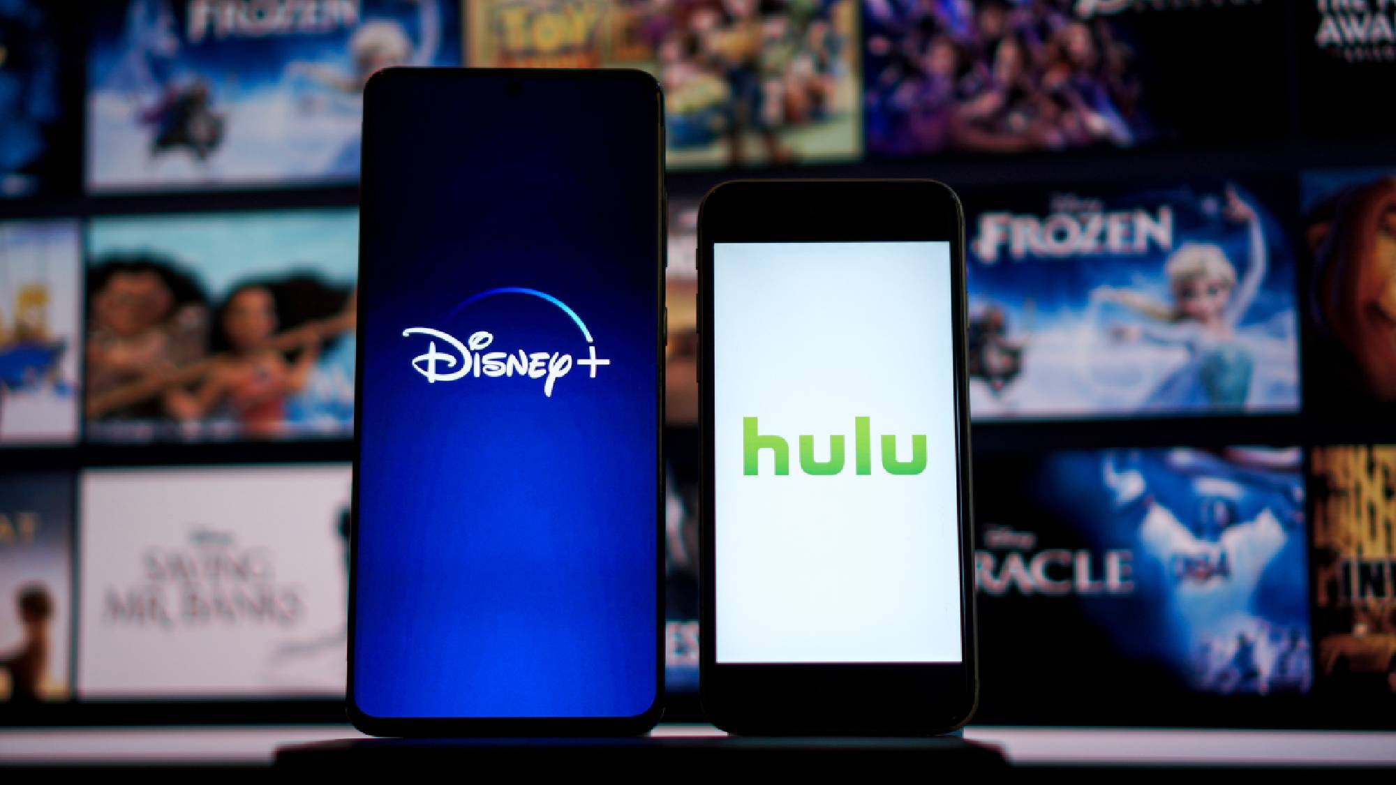 Two smartphones showing the Disney+ and Hulu logos