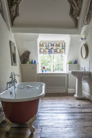 Bathroom with freestanding bath, pedestal basin and wood floor