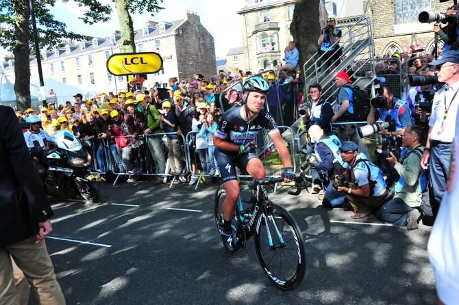 Mark Cavendish finishes holding his injured arm.