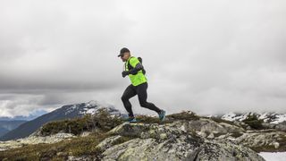 A man runs across a rocky mountaintop