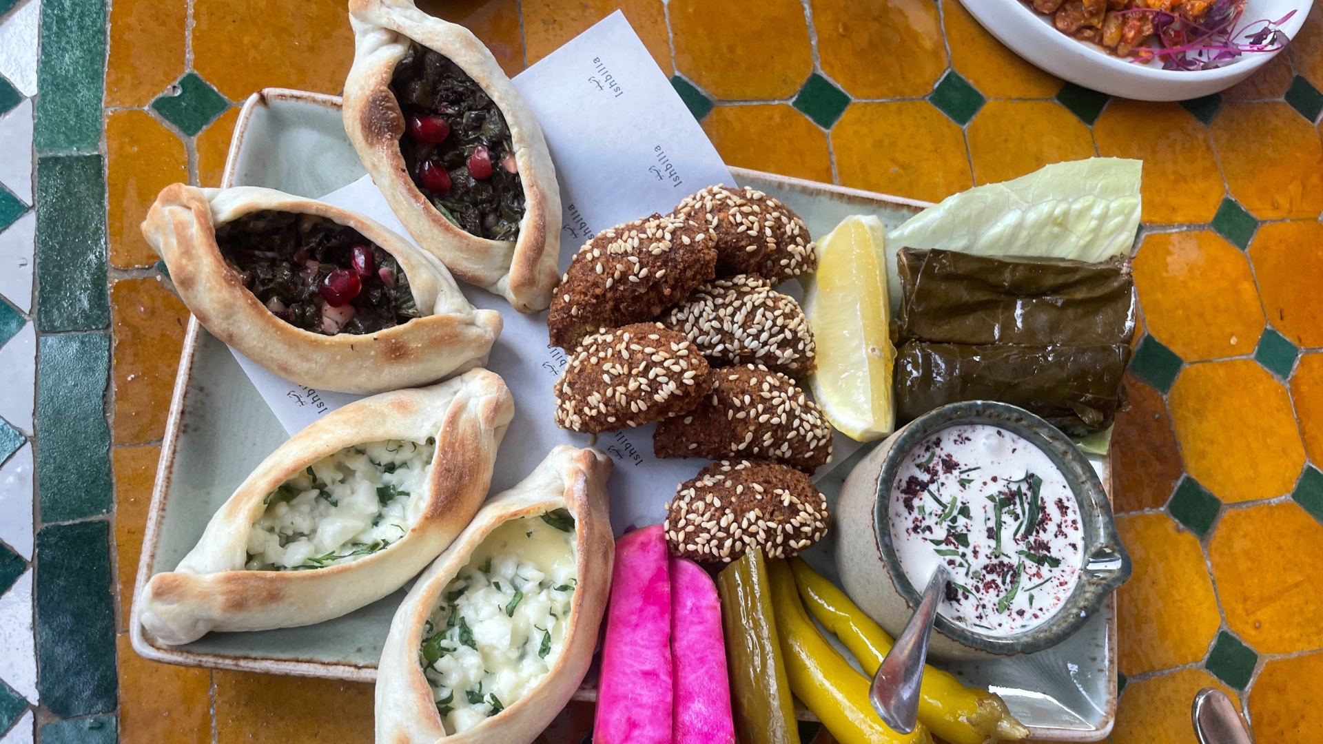an image of the mixed small clay baked and hot mezze the author tried, with the aforementioned falafel in the centre