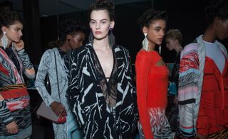 female models wearing black red and white in a marble print knit