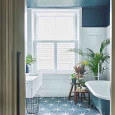 bathroom with bathtub and white window 