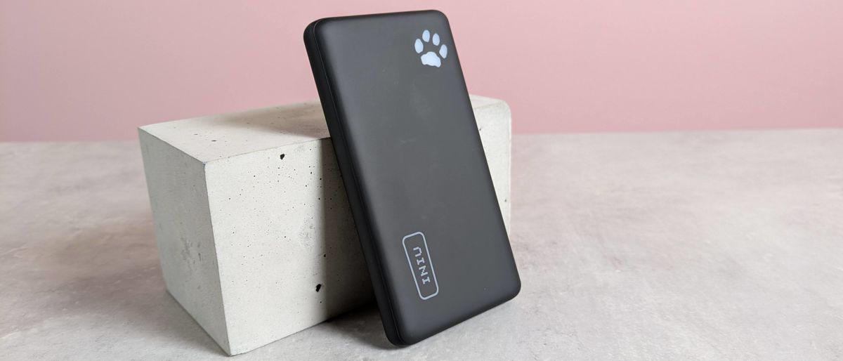 Iniu B41 power bank leaning on plinth on desk with pink background