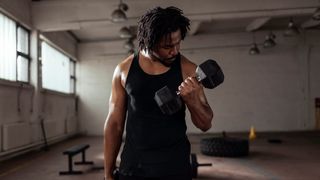 Man trains his biceps with a set of dumbbells
