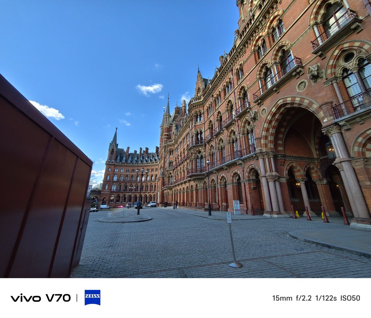 Wide-angle view of St Pancras Renaissance Hotel&rsquo;s red-brick Gothic fa&ccedil;ade under a bright blue sky.