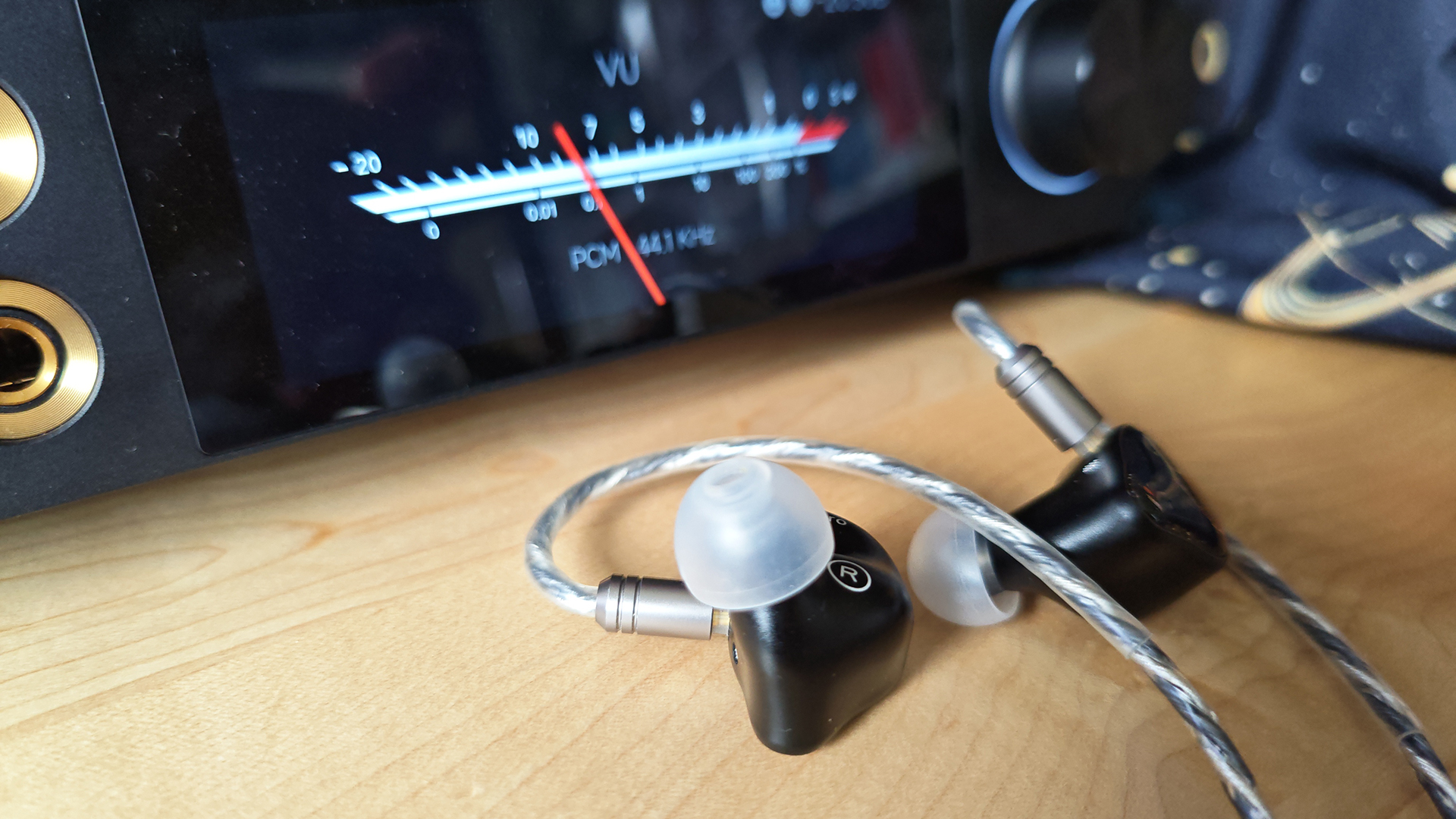 Some earbuds next to a VU metre.