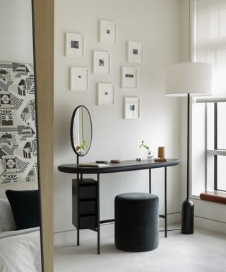 A minimalist bedroom with black vanity and mirror