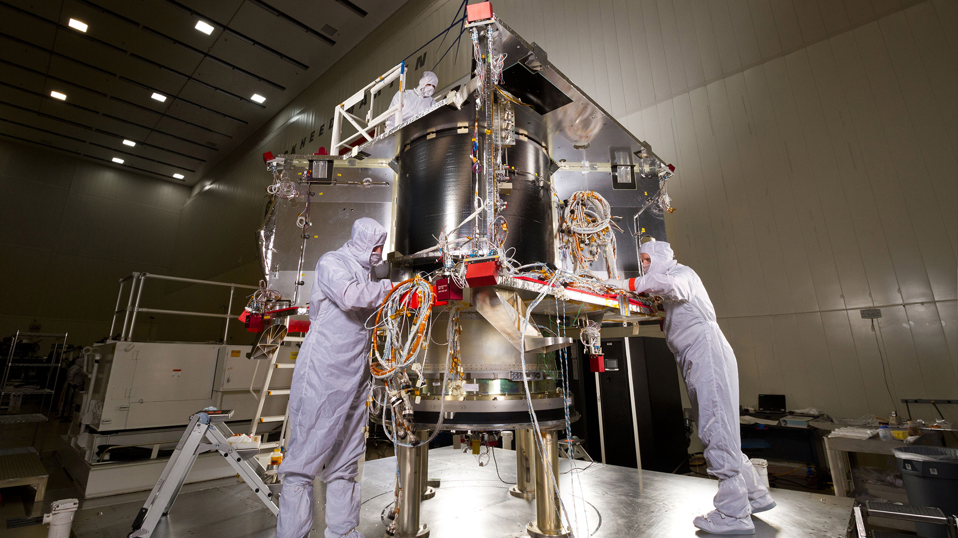Technicians assemble the OSIRIS-REx spacecraft in a Lockheed Martin Space clean room facility near Denver, Colorado.