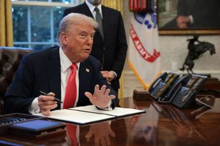 U.S. President Donald Trump signs an executive order in the Oval Office at the White House on February 25, 2025 in Washington, DC.