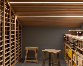 Basement wine cellar with wood storage and wood stools and ceiling lighting strips