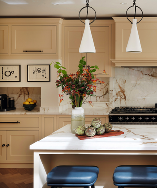 kitchen with pale yellow cabinetry and marble