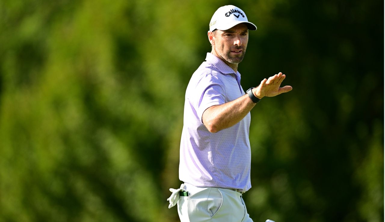 Wilson waves his hand whilst holding his putter