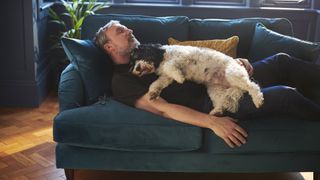 Man asleep on sofa with dog