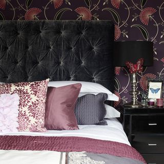 bedroom with printed wall and bed with pillows