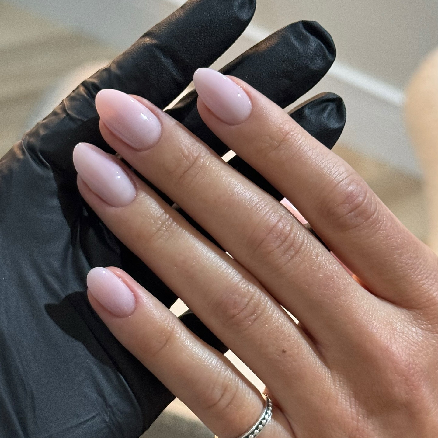 A close-up of an almond-shaped lavender manicure