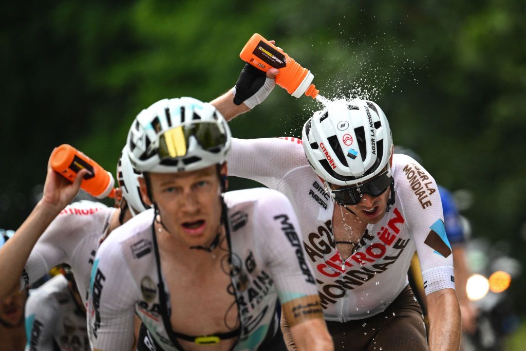 AG2R Citroen Team's Australian rider Ben O'Connor douses himself with water to cool down as he cycles in the ascent of the Col de la Loze during the 17th stage of the 110th edition of the Tour de France cycling race, 166 km between Saint-Gervais Mont-Blanc and Courchevel, in the French Alps, on July 19, 2023. (Photo by Marco BERTORELLO / AFP)