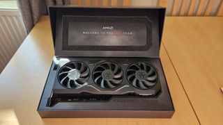 AMD Radeon 7900 XTX in box on woodgrain table