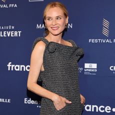 Diane Kruger wears a gray dress on the red carpet in August 2025