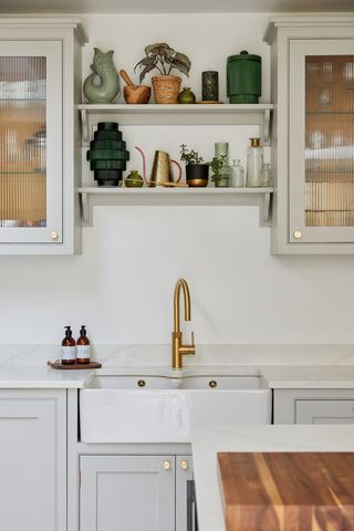 neutral kitchen with sink, shelves and cabinetry