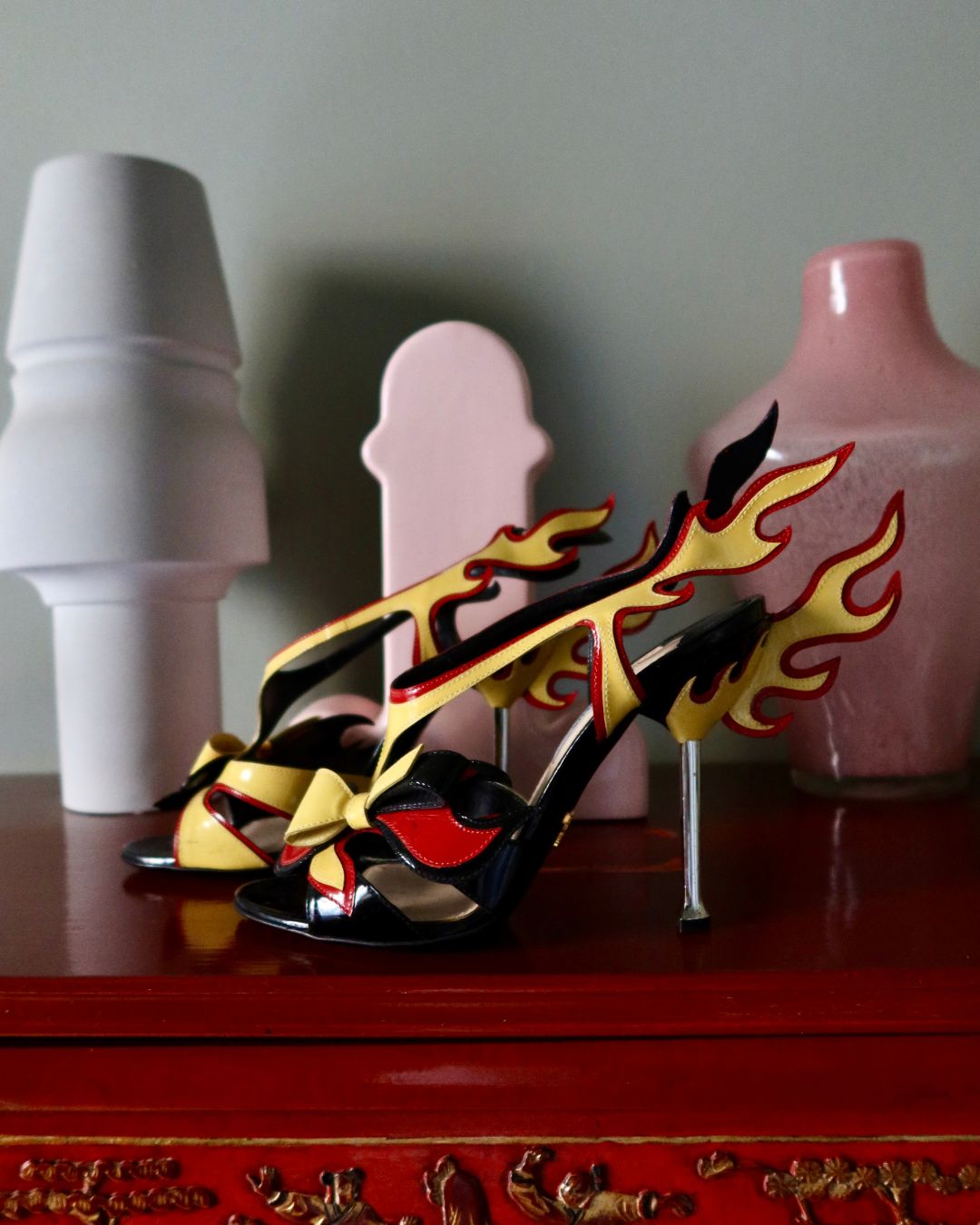 a pair of prada flame heels on a mantelpiece