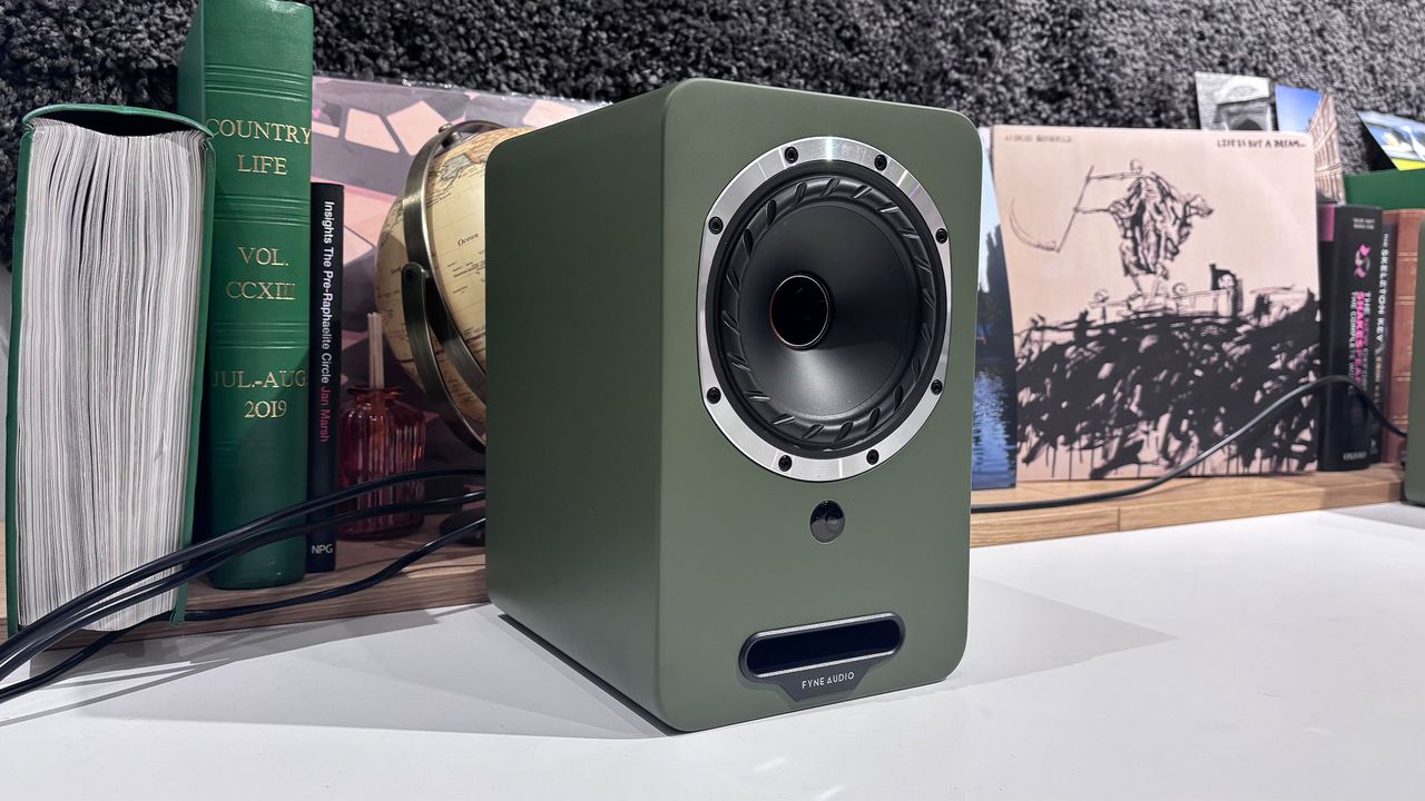 Fyne Audio Cubitt 5 speakers in olive green finish, placed on white table with records in background