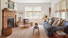 Long living room ideas featuring a blue sofa, wooden fireplace and jute rug.