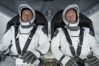 NASA astronauts Bob Behnken and Doug Hurley sit inside SpaceX's Crew Dragon spacecraft during a fully integrated test of critical crew flight hardware on March 30, 2020.