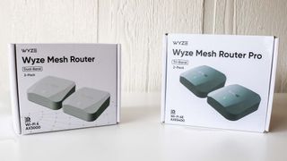 Wyze Mesh Router and Wyze Mesh Router Pro in their packaging on a table