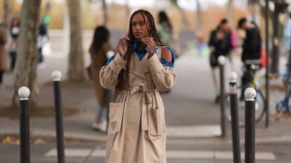 Hanna Lhoumea seen wearing a shoulder free trenchcoat and givenchy sunglasses, outside Victoria/Tomas during Paris Fashion Week