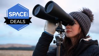 Skywatching writer Kimberley Lane holds the Celestron Skymaster 15x70 binoculars on a tripod